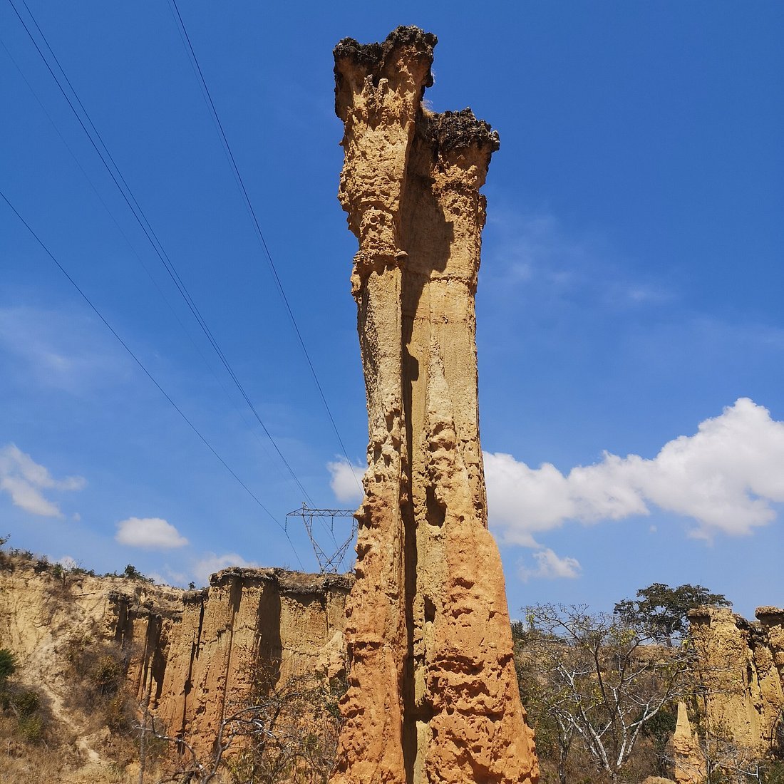 A spectacular tall freestanding sandstone pillars of Isimila canyon standing under a bright blue sky