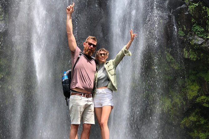 Spectacular high 80-meter Materuni waterfall crashing into a plunge pool surrounded by dense green jungle foliage
