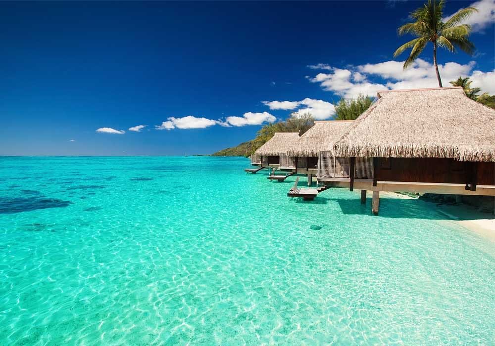 Traditional wooden dhow boat sailing on turquoise water lagoons under blue skies in Zanzibar